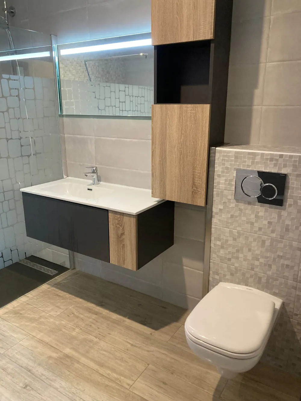 Salle d'eau rénovée avec meuble vasque suspendu bois et anthracite, WC suspendu et douche à l'italienne.